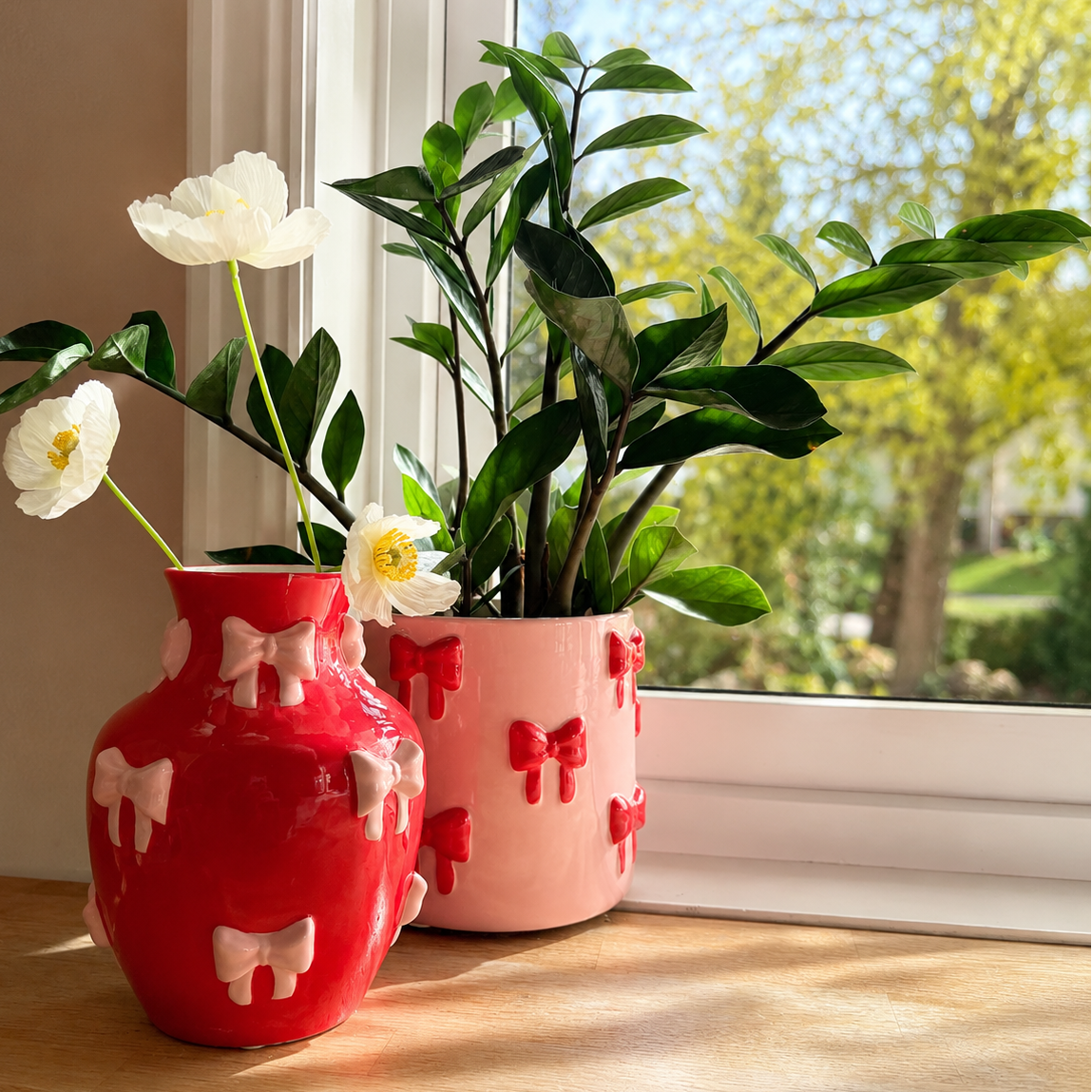 Sett med vase og potte i rosa og rød med sløyfer, perfekt for fargerik og søt jentete dekor i et fargerikt hjem
