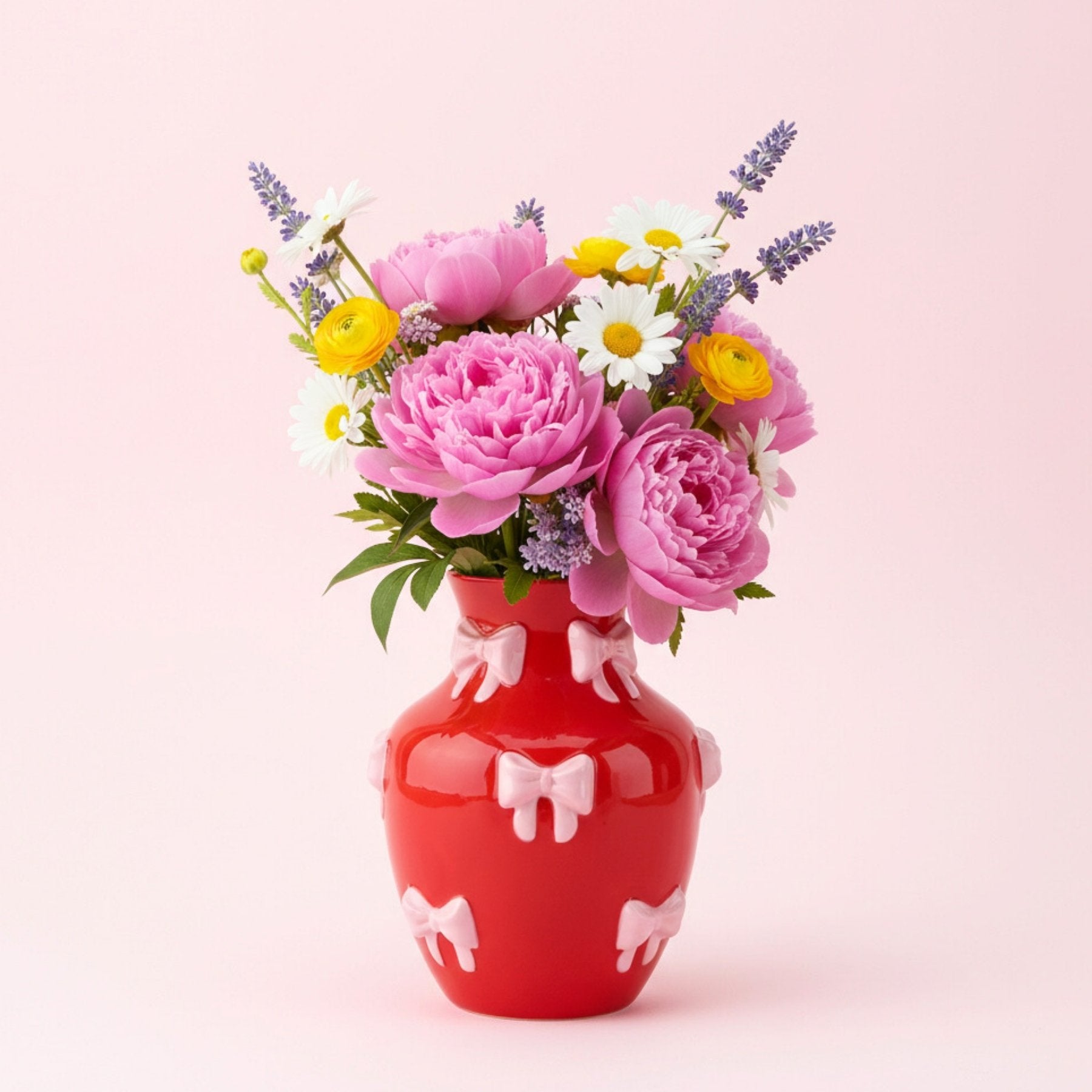 Søt vase med sløyfer plassert på bord som fargerik dekor