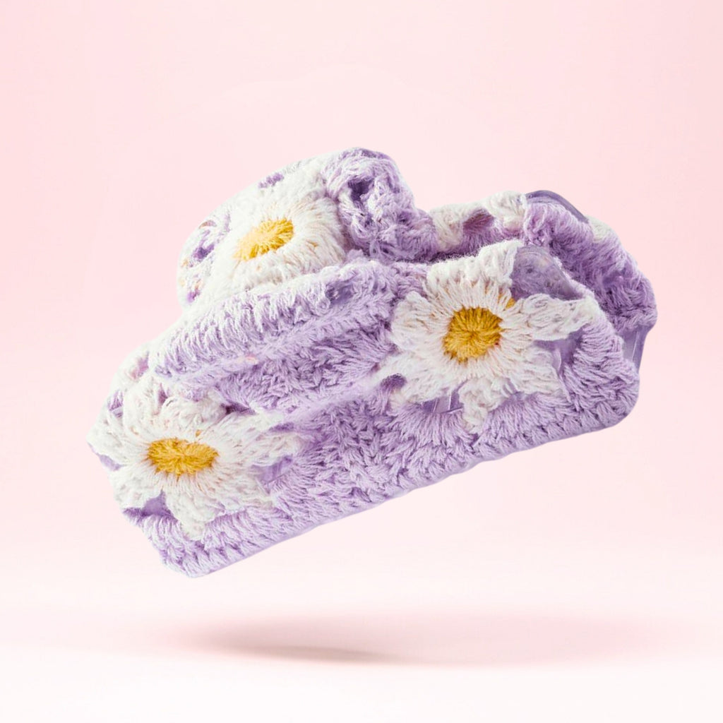 Lilla krosje hårklype med blomsterdesign fotografert i studio med fokus på detaljer og håndlaget tekstur.