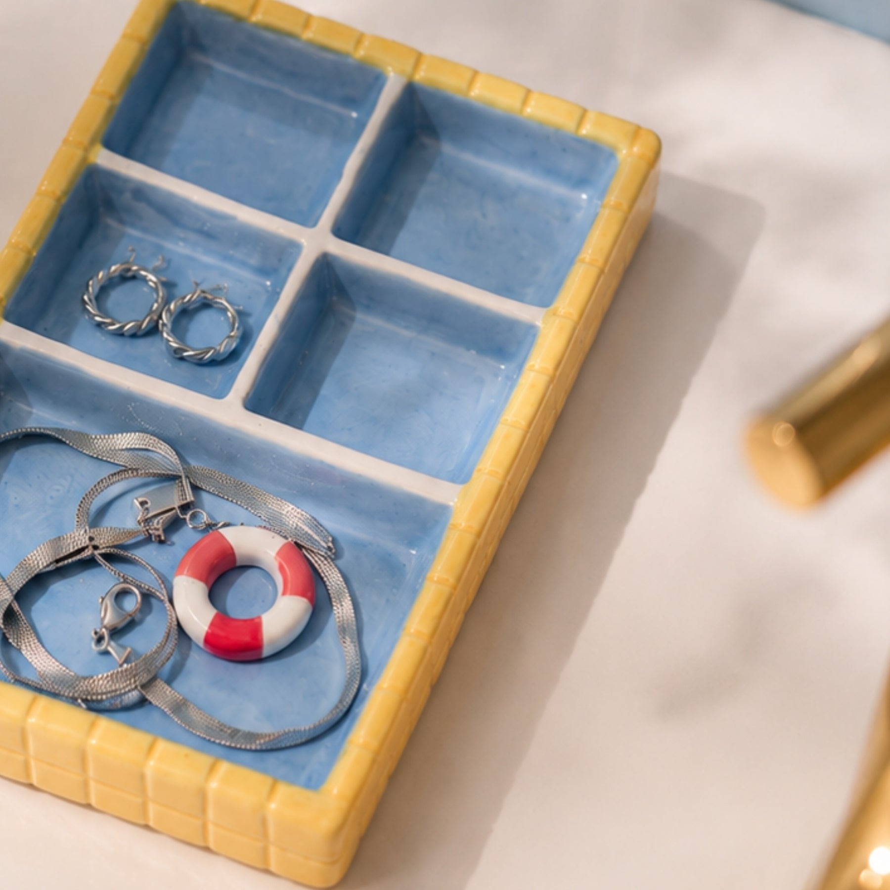 Retroinspirert smykkeholder i pastellfarger styled som dekor på moderne bad