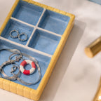 Retroinspirert smykkeholder i pastellfarger styled som dekor på moderne bad