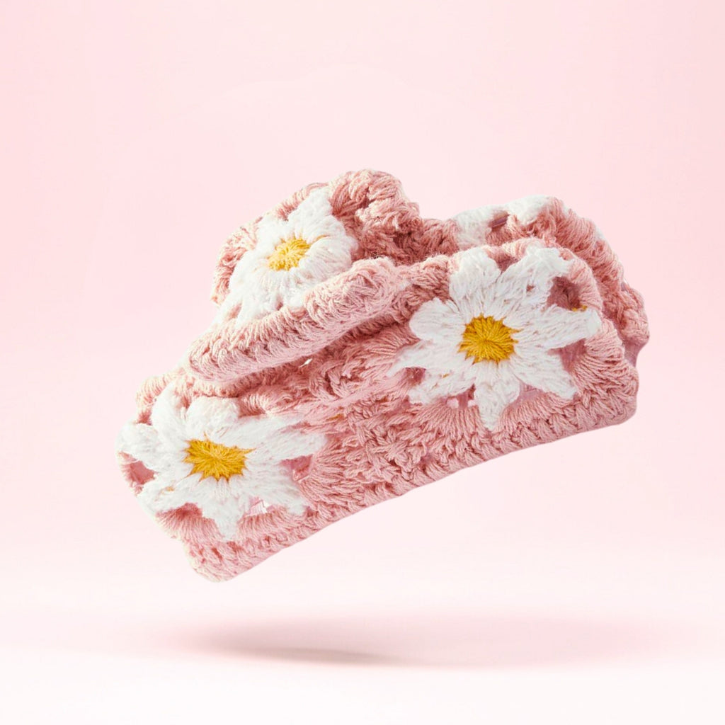 Nærbilde av håndlaget rosa hårklype med crochet blomster