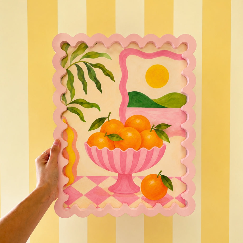Rosa bilderamme med appelsinmotiv som dekorasjon i et fargerikt hjem.