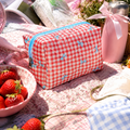 Søt og rutete toalettmappe i piknik setting perfekt for sminkeoppbevaring og som sminkeveske