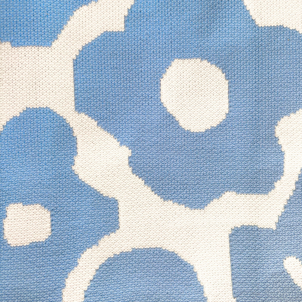 Minimalistisk studiofoto av retro totebag inspirert av skandinavisk design og fargerike blomsterformer.
